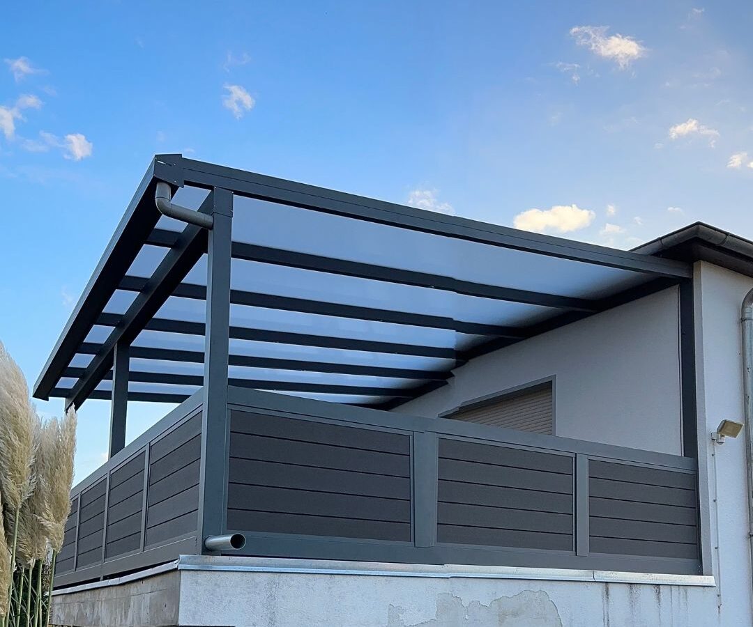 terrassenueberdachungen-goettingen-wpc-gelaender Aluminium-Terrassendach mit dunklem WPC-Geländer auf einer erhöhten Terrasse